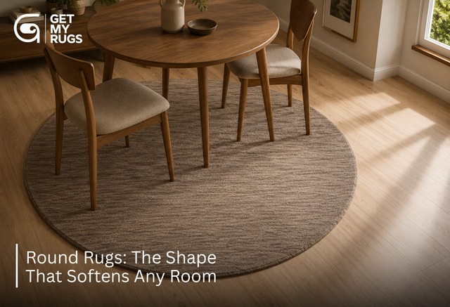 Round area rug in heathered taupe-brown wool placed under a round dining table, softening the room's straight lines
